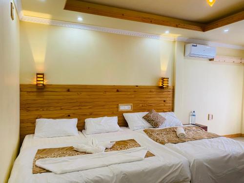 GaafaruMariana Inn的一间卧室配有两张带白色床单的床