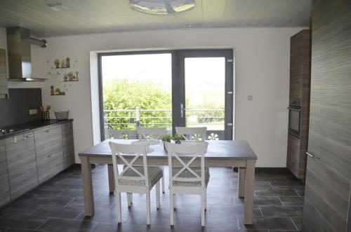 塞尔方丹Gîtes Paille-Foin的厨房配有木桌和白色椅子