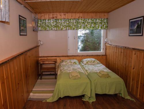 伊纳利卡尔皮卡塔奴酒店的带窗户的客房内的两张床