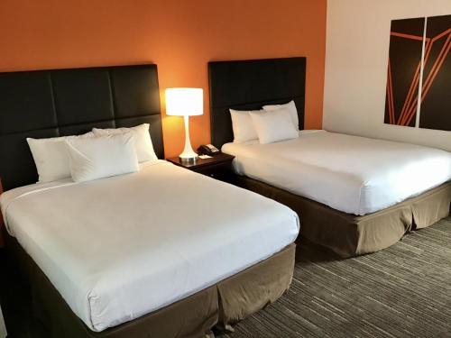 斯波坎Howard Johnson by Wyndham Spokane的酒店客房,设有两张床和一盏灯