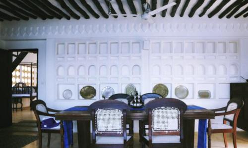 ShelaShela Bahari的墙上一张桌子,上面有椅子和盘子