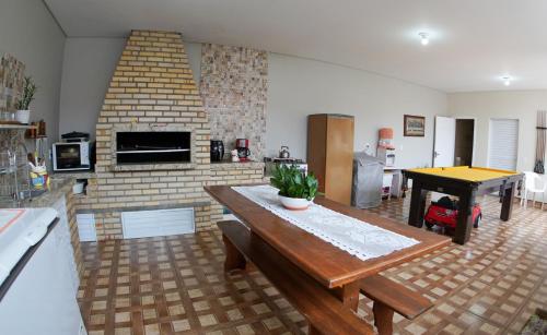 瓜尔达恩巴Casas do Preto的客厅配有桌子和砖砌壁炉