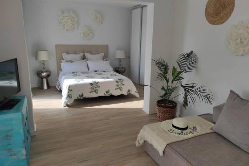 库姆布勒德尔索尔Precioso apartamento en una villa con piscina en Cumbre del Sol Moraira Benitachell的白色卧室配有床和沙发