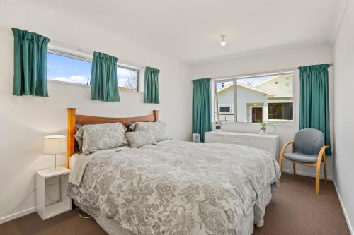 惠灵顿Karori Kabin - Karori Holiday Home的一间卧室配有大床和绿色窗帘