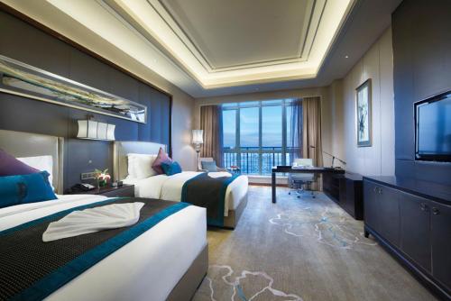 天津天津京基皇冠假日酒店的酒店客房设有两张床和一台平面电视。