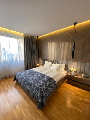 贝尔格莱德DOM Boutique Apartments - Park View的一间卧室设有一张大床和一个大窗户