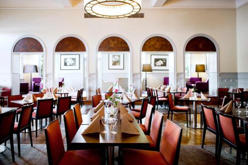 卡尔斯塔德Elite Stadshotellet Karlstad, Hotel & Spa的一间带桌椅和吊灯的餐厅