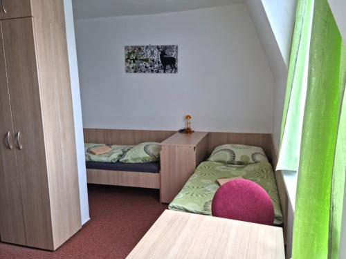 上贝奇瓦Veghouse - Penzion u pláže的小房间设有两张床和一张粉红色的椅子