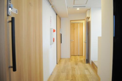 大阪04 village Namba Mixed Dormitory room - Vacation STAY 64862v的走廊上设有门,铺有木地板