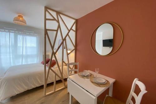 圣马洛Héol的一间卧室配有一张床、镜子和一张桌子