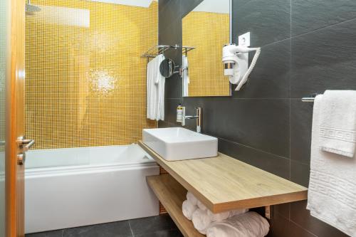 Faja GrandeVillas do Mar的浴室配有盥洗盆和浴缸。
