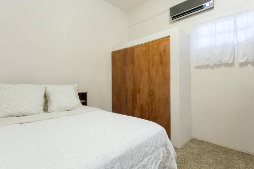 里奥格兰德Comfortable and Affordable Deal Close to Beach and Rainforest的卧室配有白色的床和木门