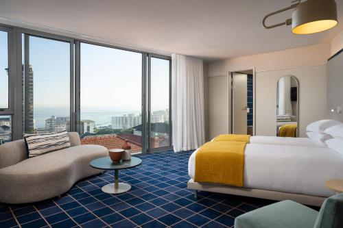 开普敦Home Suite Hotels Sea Point的酒店客房,配有床和沙发