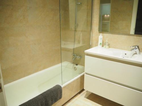 桑特费柳德吉克索尔斯Apartament per families a Sant Feliu amb piscina的带浴缸、水槽和淋浴的浴室