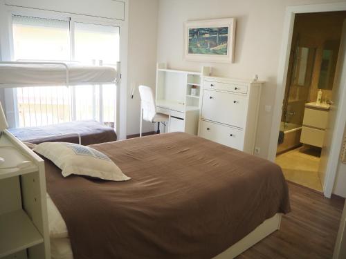 桑特费柳德吉克索尔斯Apartament per families a Sant Feliu amb piscina的一间卧室配有两张床、一张桌子和一张书桌