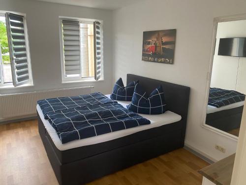 新勃兰登堡Mitten im Herzen von Neubrandenburg的一间卧室配有一张带蓝色床单和枕头的床。