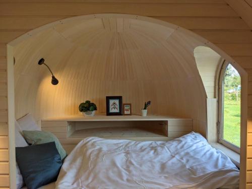 卡斯特尔莱Camping Houtum的一张位于带拱形窗户的房间内的床铺