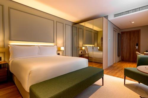 圣若泽K-Platz Hotel的卧室配有一张白色的大床和一张沙发。