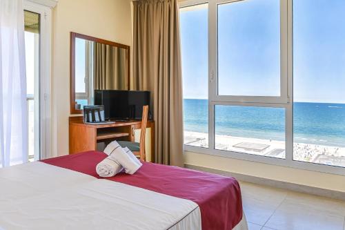 米兰马瑞提那阿德里亚酒店的一间卧室配有一张床,享有海景