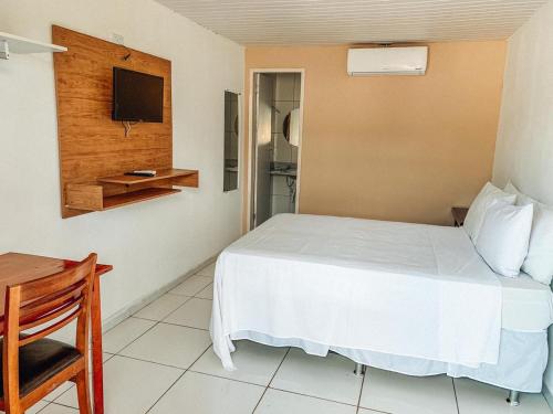 特里温福Pousada Alpes的一间酒店客房,配有一张床和一台电视