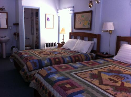 PortolaPullman House Inn的酒店客房带两张床和一间浴室