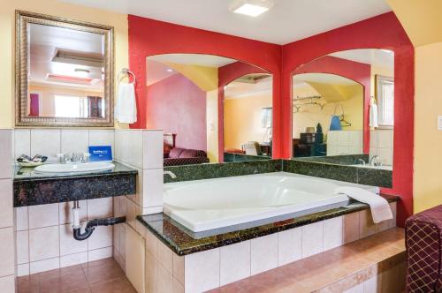 奥兰治天空棕榈汽车旅馆 - 橙色的带浴缸和盥洗盆的浴室