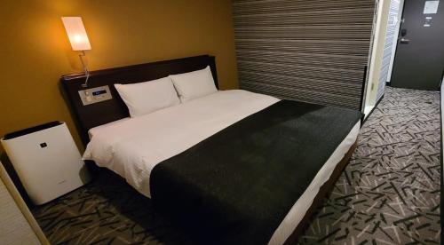东京Ai Hotel Keikyu Kamata-ekimae的一间位于酒店客房内的带大床的卧室