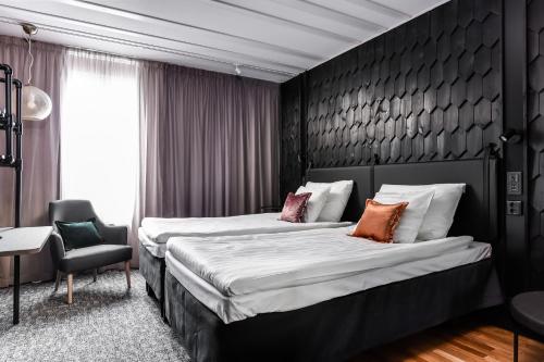 奥卢原始艾瑞娜斯科酒店的酒店客房,配有两张床和椅子