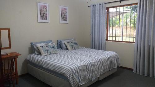 圣卢西亚6 Fish Eagles的一间卧室配有一张带蓝色和白色床单的床和窗户。