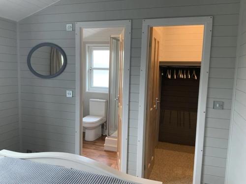 达尔比蒂Holly Blue - Cosy wooden lodge Kippford的卧室设有通往浴室的门