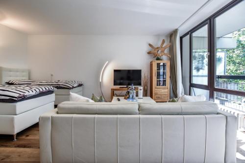科隆Domicile Cologne的白色的客房配有两张床和电视。