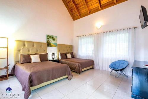 拉罗马纳Luxury Villa Casa De Campo的酒店客房设有两张床和电视。