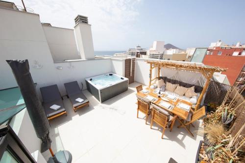 厄尔梅达诺MEDANO4YOU Tina's Jacuzzi Terrace Playa Chica的大楼顶层带热水浴池的阳台