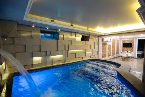埃里温GOLDEN SECONDS Hotel的一个带瓷砖墙的房间的游泳池