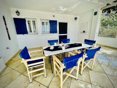 佩里萨Villa Arietta Santorini的一间配备有蓝色椅子和桌子的用餐室