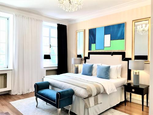 华沙Luxury Suites & Apartments MONDRIAN Market Square II的一间卧室配有一张大床和一张蓝色椅子