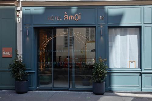 巴黎Hôtel Amoi Paris的前面有两株盆栽植物的酒店直销店