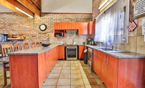 玛洛斯帕克Nghala Self-catering Holiday Home的一个大厨房,配有橙色橱柜和柜台