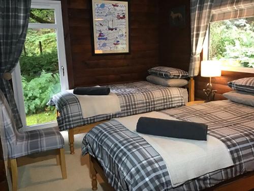 达农Fox Lodge Traditional Log Cabin的一间卧室设有三张床和窗户。