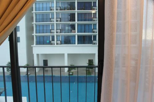 莎阿南Cloud Stay at Setia Alam的享有大楼和游泳池景致的阳台