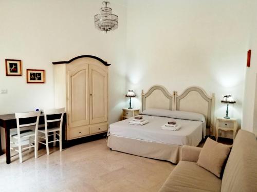 加拉蒂纳Palazzo Cavoti的一间卧室配有一张床、一张桌子和一张沙发