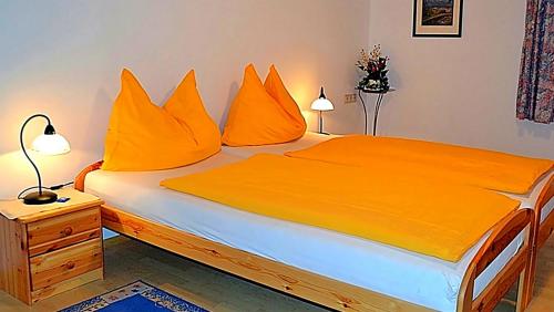 巴德哥依斯恩Ferienwohnung Neuhuber的一间卧室配有带橙色枕头的床
