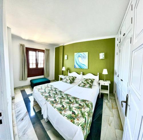 圣地亚哥海滩塔帕胡加公寓的一间卧室设有一张大床和绿色的墙壁