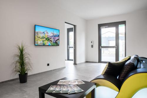 菲尔特Hotel Grüne Elster的客厅配有沙发和墙上的电视
