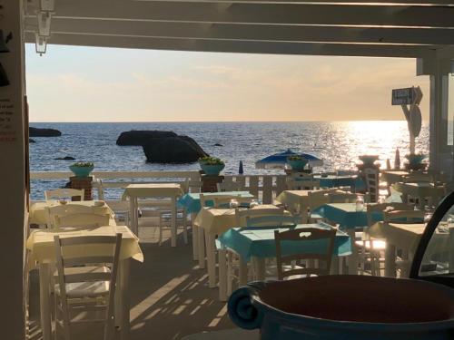 伊斯基亚Agata Suite的海滩上带桌椅的餐厅