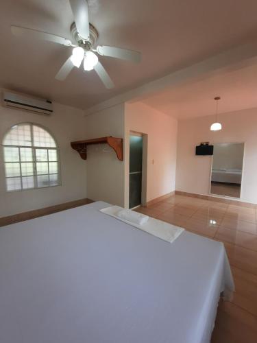 JuigalpaEthos Inn的卧室配有白色的床和吊扇