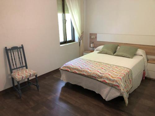 普韦布拉桑纳比亚El Mirador de la Villa的一间卧室配有一张大床和一把椅子