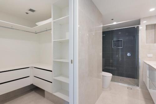 黄金海岸Allunga Stunning Beach Side Apartment的带淋浴和卫生间的白色浴室