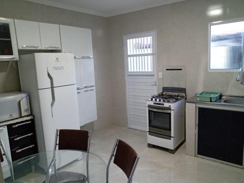 卡宁德圣弗朗西斯科Casa Beira Rio Xingó的厨房配有白色冰箱和玻璃桌