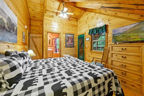 赛维尔维尔GYPSY ROAD - Privacy! Log Cabin with Hot Tub, WiFi, DirecTV and Arcade的一间卧室配有一张床和吊扇